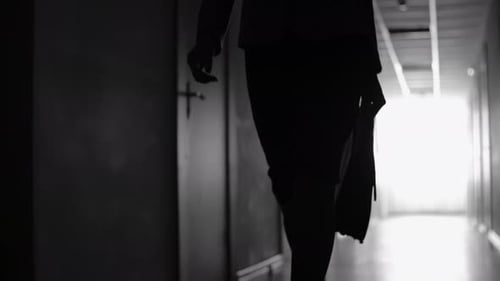 Woman Walking Down Dark Hallway with Briefcase