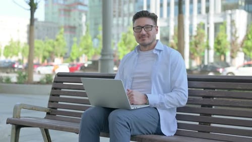 Man Working on Laptop in Urban Setting