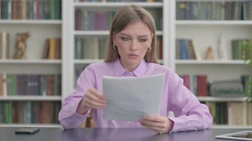 Excited Woman Reads Good News at Desk