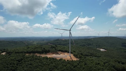 Wind Turbines Rotating on Green Hilly Landscape