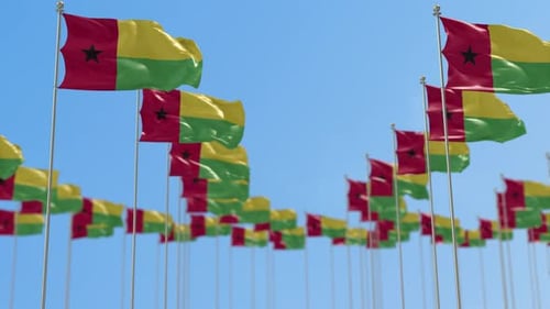 Guinea-Bissau Flags Waving in Wind Against Blue Sky