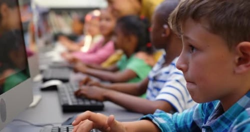 Side view of mixed-race schoolkids studying on computer in the classroom 4k