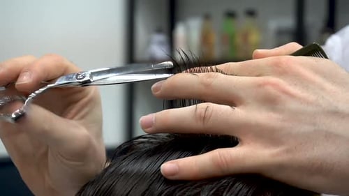 Hairdresser Cuts a Man with Scissors