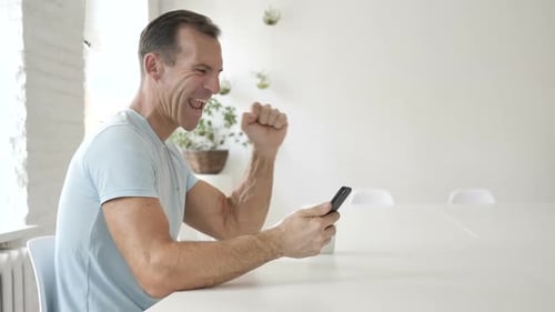 Man With Phone Reacts to Good News