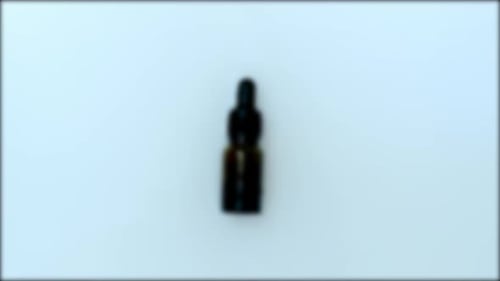 Glass Bottle with Dropper on White Background