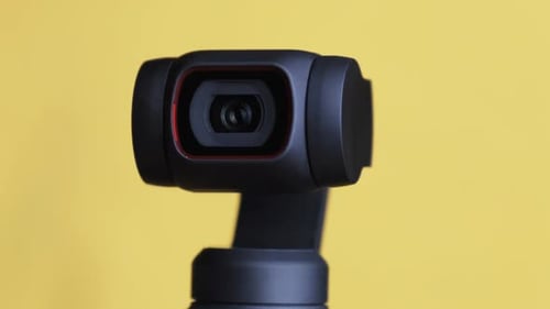 Gimbal Camera Rotating Against Yellow Background