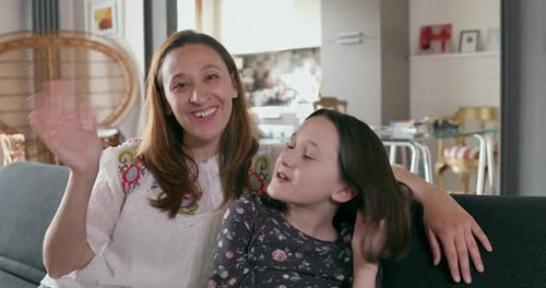 Smiling Mother and Daughter Waving From Home