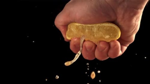 Hand Squeezes Lemon Releasing Fresh Juice