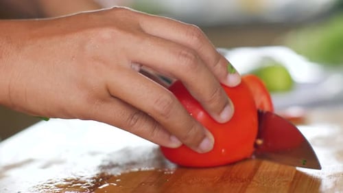 Slicing a Fresh Tomato on a Cutting Board