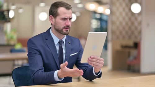 Man in Suit Confused by Tablet Technology
