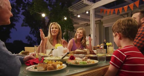 Multigenerational Family at Outdoor Dinner Party at Night