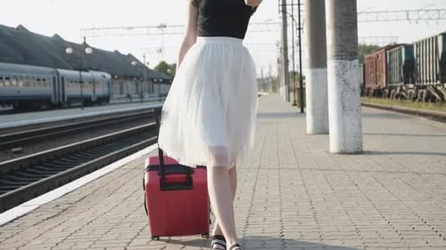 Woman Pulling Suitcase at Train Platform