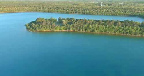 Beautiful spring nature landscape with a blue lake water between green forest