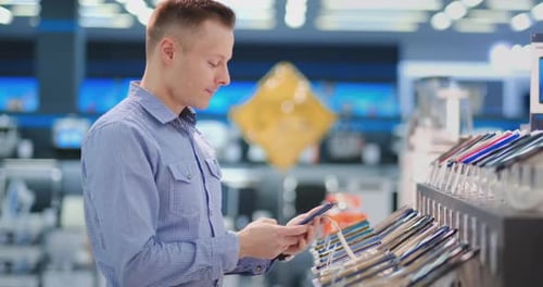Man Trying Out New Smart Phone. Tech Store Interior.