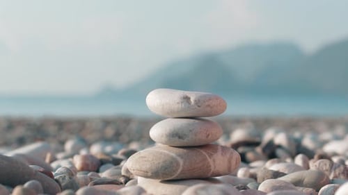 Hand Making Stone Tower on Sea Beach. Meditation at Summer Holidays