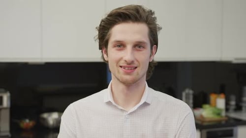 Young Adult Smiling in a Modern Kitchen