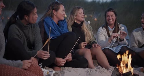 A Simple Group of Friends Having a Conversation By the Beach Bonfire