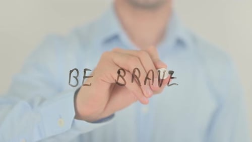 Sei mutig, Mann, der auf transparentem Bildschirm schreibt