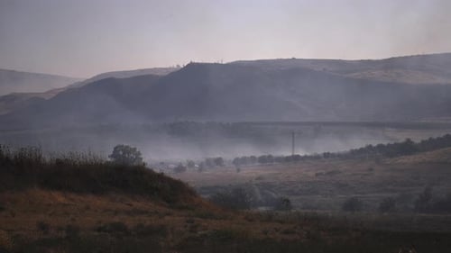 Smog spreading above the grass field