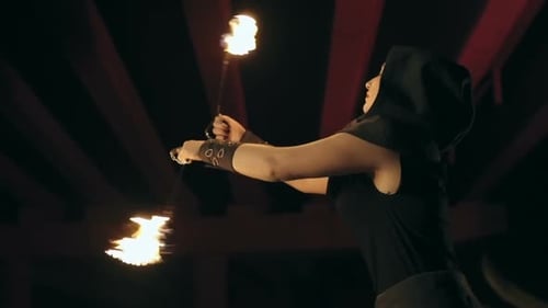 Woman Performing with Fire Staffs in Urban Setting