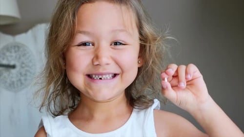Retrato de menina está mostrando seu dente de leite perdido e sorrindo
