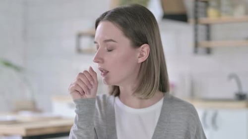 Young Adult Woman Coughing in Kitchen