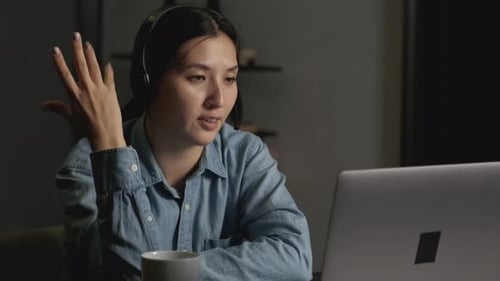 Gros plan d'une jeune femme asiatique souriante dans un casque avec un microphone pour le travail