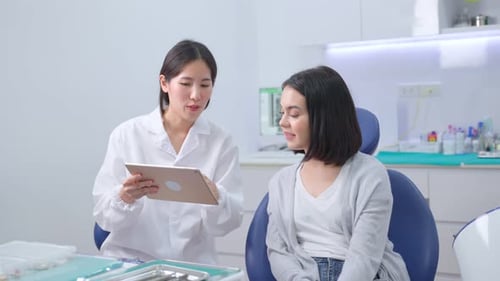 Dentist Explains Treatment to Patient in Office