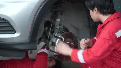 Roda de verificação e reparo de dois mecânicos masculinos do carro, serviço de garagem, técnico de manutenção de automóveis