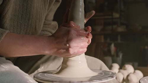 Potter soulève de l'argile humide sur la roue de Potter