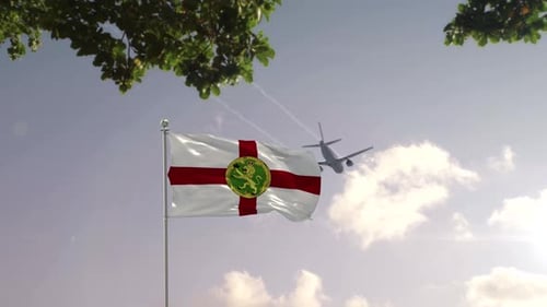 Alderney Flag Waving with Airplane Flying Over Modern City