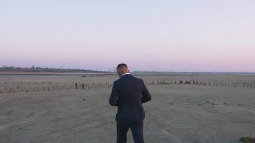 Handsome Bearded Mature Man in Suit Walking Outdoors on Beach During Sunset Slow Motion