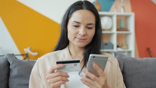 Woman Using Credit Card on Smartphone at Home