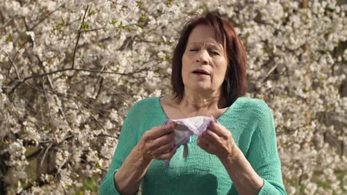 Woman Sneezing Near Blooming Tree