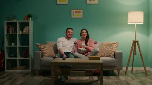 Couple Watches Television and Eats Popcorn