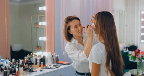 Makeup Artist Applying Makeup to Model in Salon