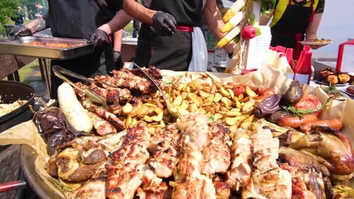 Street Food Festival A Chef in Black Clothes and Gloves Adds a New Batch of Sausages