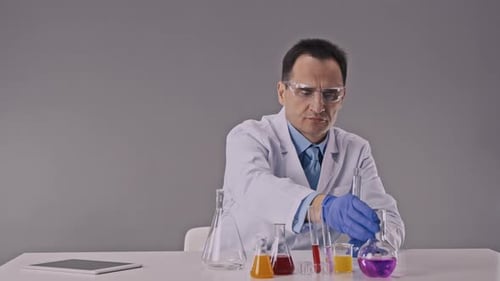 Un chimiste en blouse blanche dans un laboratoire moderne mène des expériences