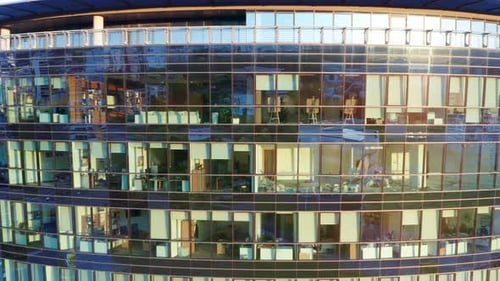 Offices in a modern high rise commercial building with glass facade at sunset