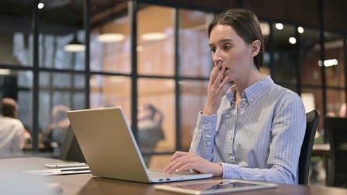 Woman At Desk Is Shocked By Laptop