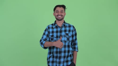 Smiling Young Adult Gives Thumbs Up on Green Screen