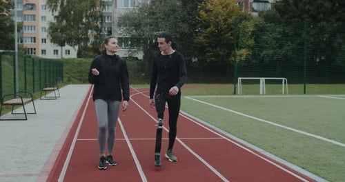 Athlete with Prosthetic Leg Walking with Friend