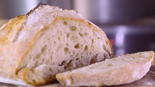 Freshly Baked Sourdough Bread Sliced On Wooden Board - close up, slider left shot