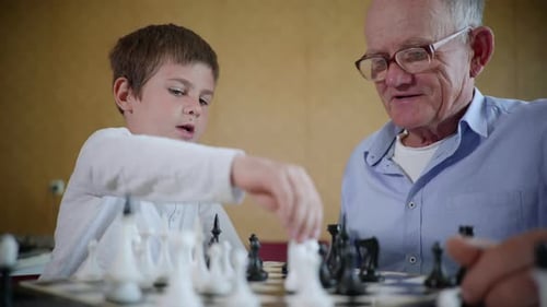 Brettspiele, Ein älterer Mann mit Brille für Vision und ein glückliches süßes männliches Kind haben Spaß zusammen