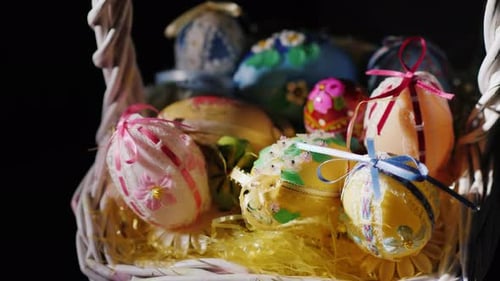 Korb mit Osterdekorationen auf schwarzem Hintergrund