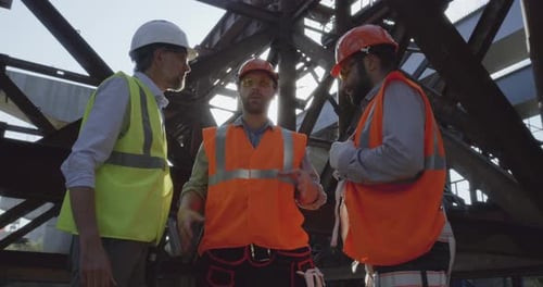 Construction Workers Talking At Construction Site on Sunny Day