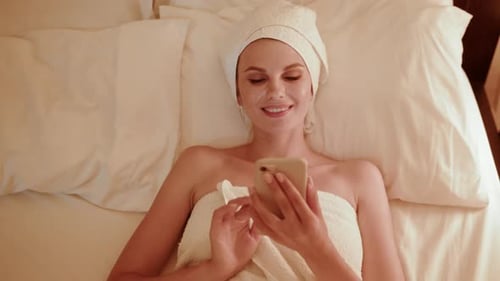 Top View of Girl Using Smartphone While Lying in Bed at Night