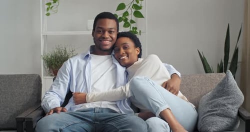 Smiling Couple Relaxing Together on Sofa at Home