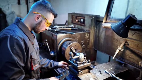 Young Adult Working with Metal Machine in Factory