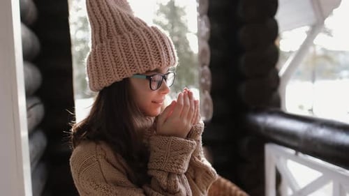 Girl Warming Hands on Snowy Winter Day